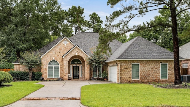 25818 Overlake Dr, Spring, TX 77380 - view of front of property with driveway, brick siding, a garage, a shingled roof, and a front yard