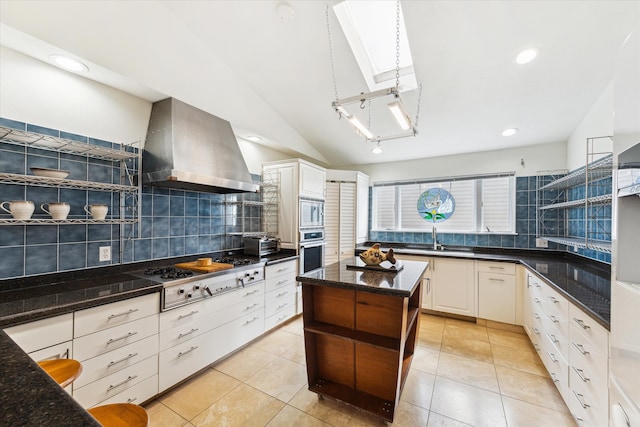 2414 Baycrest Dr, Houston, TX 77058 - kitchen featuring appliances with stainless steel finishes, exhaust hood, open shelves, backsplash, and vaulted ceiling