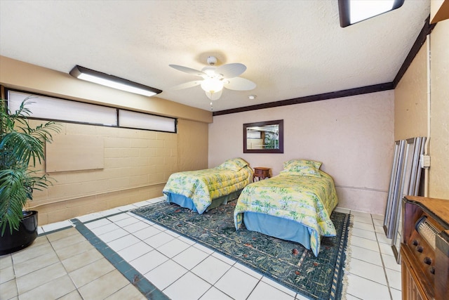 2414 Baycrest Dr, Houston, TX 77058 - bedroom with light tile patterned flooring, a textured ceiling, concrete block wall, and ceiling fan