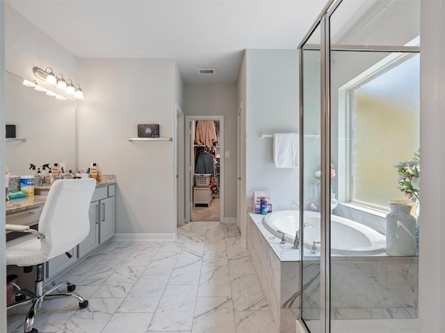 2815 Skerne Forest Dr, Spring, TX 77373 - bathroom featuring marble finish flooring, a walk in closet, a bath, vanity, and baseboards