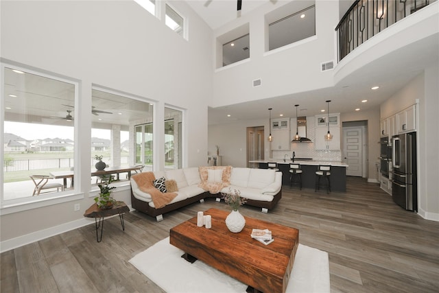 413 Stratus View Ct, Katy, TX 77493 - living room featuring a ceiling fan, healthy amount of natural light, wood finished floors, and a high ceiling