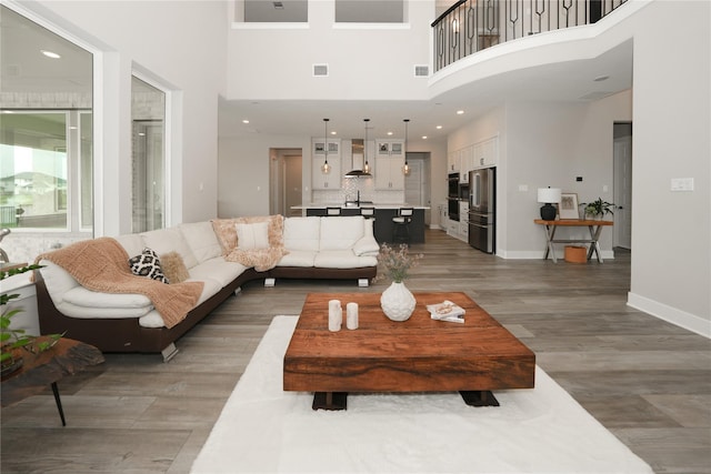 413 Stratus View Ct, Katy, TX 77493 - living area featuring light wood-style flooring, a high ceiling, baseboards, and recessed lighting