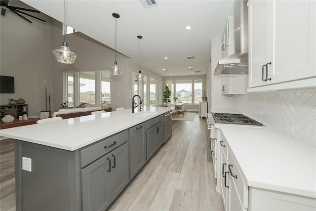 413 Stratus View Ct, Katy, TX 77493 - kitchen featuring a sink, gray cabinetry, stainless steel dishwasher, a spacious island, and wall chimney exhaust hood
