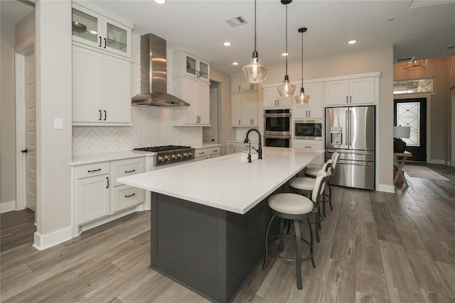 413 Stratus View Ct, Katy, TX 77493 - kitchen featuring stainless steel appliances, wall chimney exhaust hood, a sink, tasteful backsplash, and white cabinets