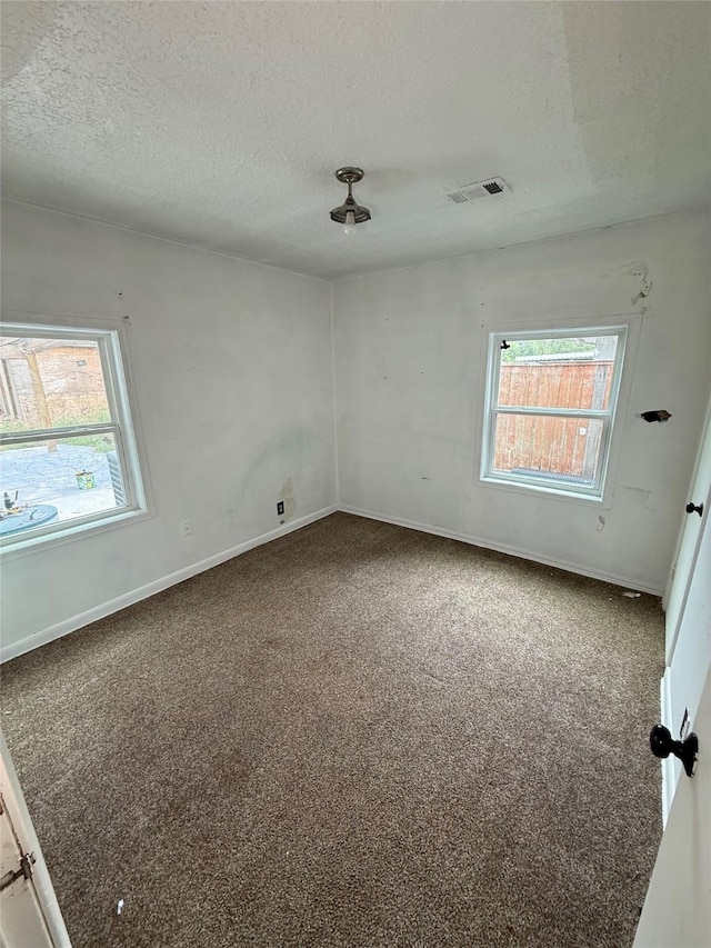 10211 Glenmawr Dr, Houston, TX 77075 - carpeted empty room featuring a textured ceiling, plenty of natural light, and baseboards