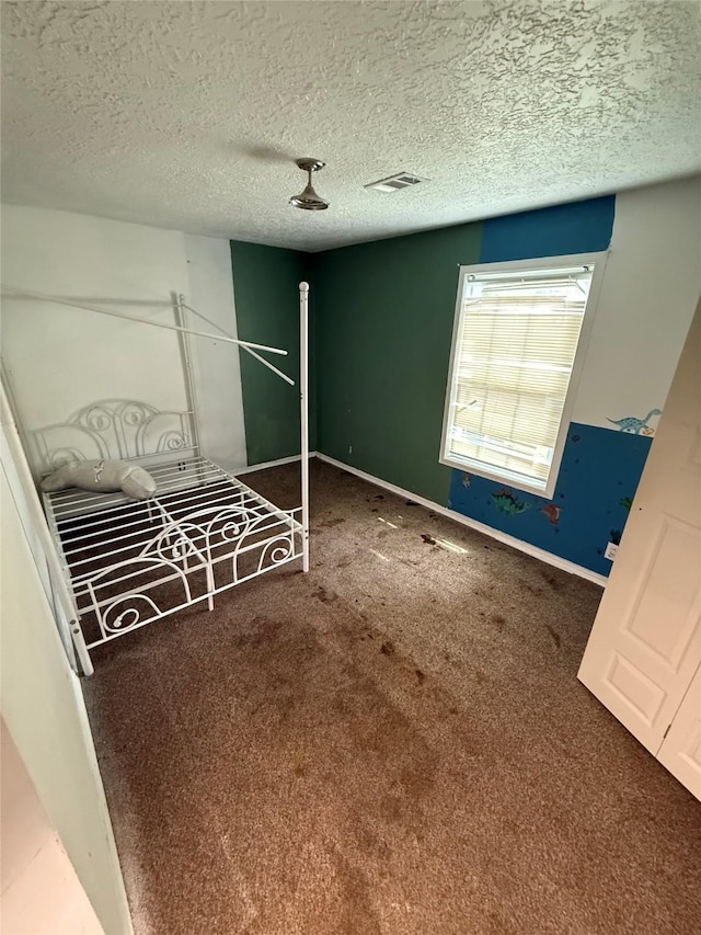 10211 Glenmawr Dr, Houston, TX 77075 - unfurnished bedroom featuring carpet flooring, a textured ceiling, and baseboards