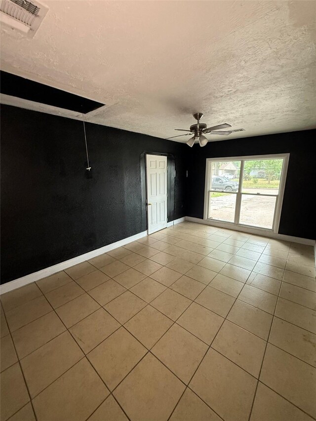 10211 Glenmawr Dr, Houston, TX 77075 - unfurnished room with a ceiling fan, baseboards, light tile patterned floors, and a textured ceiling