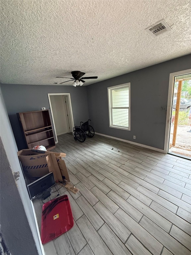 10211 Glenmawr Dr, Houston, TX 77075 - unfurnished living room with a textured ceiling, ceiling fan, wood finished floors, and baseboards