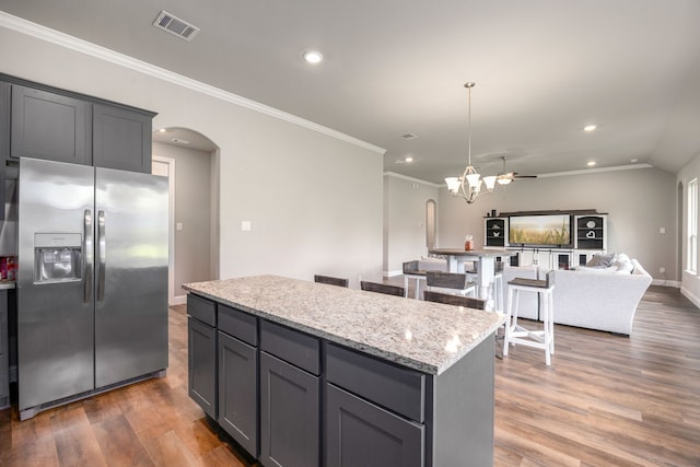 26579 Pin Oak Dr, Hempstead, TX 77445 - kitchen featuring stainless steel fridge with ice dispenser, arched walkways, a kitchen island, recessed lighting, and crown molding