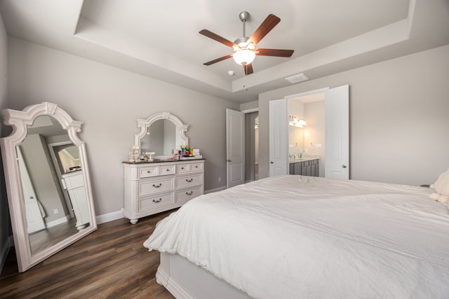 26579 Pin Oak Dr, Hempstead, TX 77445 - bedroom with a raised ceiling, dark wood-style flooring, baseboards, ceiling fan, and ensuite bathroom