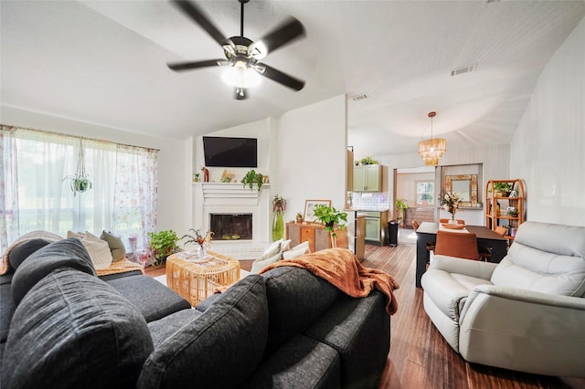 7477 Hidden Acres Dr, Cleveland, TX 77328 - living room featuring wood finished floors, vaulted ceiling, a ceiling fan, a glass covered fireplace, and a chandelier