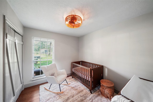 7477 Hidden Acres Dr, Cleveland, TX 77328 - bedroom with wood finished floors and a nursery area
