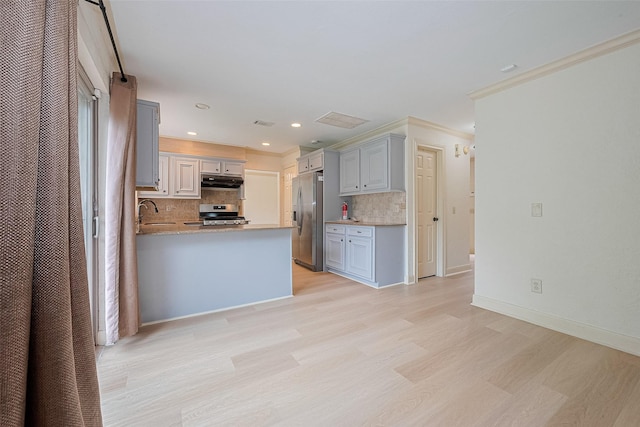 3614 Bee Bayou Ln, Sugar Land, TX 77479 - kitchen featuring appliances with stainless steel finishes, under cabinet range hood, light wood-style flooring, tasteful backsplash, and gray cabinetry