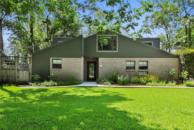 mid-century modern home with a front lawn, brick siding, and a gate