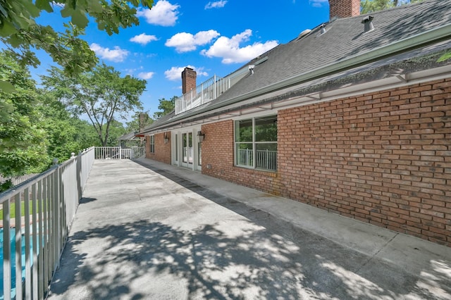 11774 Quail Creek Dr, Houston, TX 77070 - view of side of home featuring a chimney, brick siding, and roof with shingles
