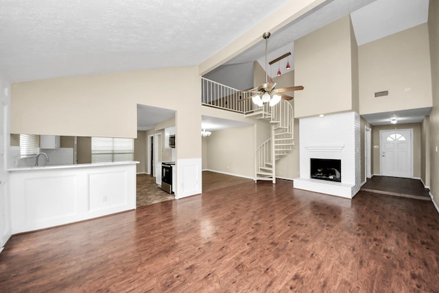 1115 Vang Ct, Crosby, TX 77532 - unfurnished living room featuring a fireplace, dark wood finished floors, a ceiling fan, high vaulted ceiling, and a sink