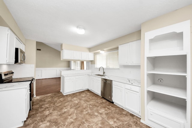 1115 Vang Ct, Crosby, TX 77532 - kitchen featuring stainless steel appliances, a sink, white cabinetry, a wainscoted wall, and a peninsula