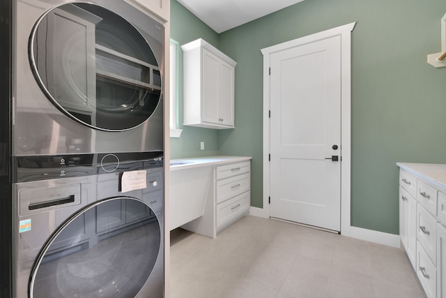 777 S Cape Royale Dr, Coldspring, TX 77331 - laundry area featuring stacked washer and clothes dryer, cabinet space, and baseboards