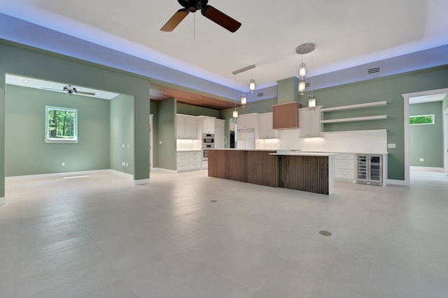 777 S Cape Royale Dr, Coldspring, TX 77331 - kitchen with beverage cooler, open floor plan, open shelves, ceiling fan, and a center island