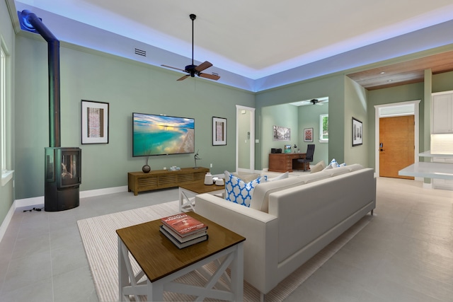 777 S Cape Royale Dr, Coldspring, TX 77331 - living room with ceiling fan, a wood stove, baseboards, and a tray ceiling