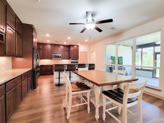 2755 Overlook Rd, Caldwell, TX 77836 - dining area featuring light wood finished floors, arched walkways, a ceiling fan, and recessed lighting