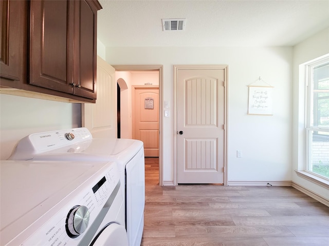 2755 Overlook Rd, Caldwell, TX 77836 - washroom featuring cabinet space, washing machine and clothes dryer, light wood finished floors, and baseboards