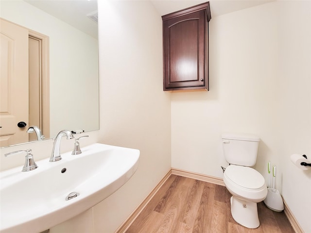 2755 Overlook Rd, Caldwell, TX 77836 - half bath featuring a sink, toilet, wood finished floors, and baseboards