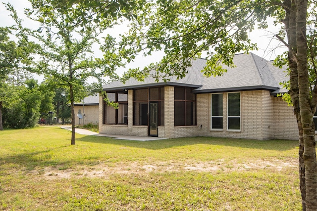 2755 Overlook Rd, Caldwell, TX 77836 - back of house featuring roof with shingles, a lawn, brick siding, and a patio area