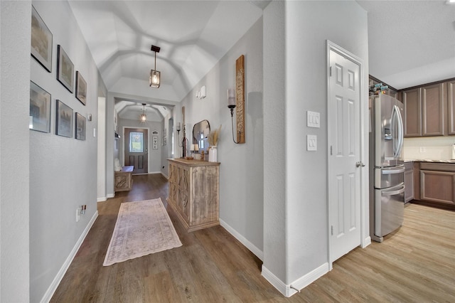 922 Golden Willow Ln, Conroe, TX 77304 - hall featuring light wood-style floors, vaulted ceiling, baseboards, and arched walkways