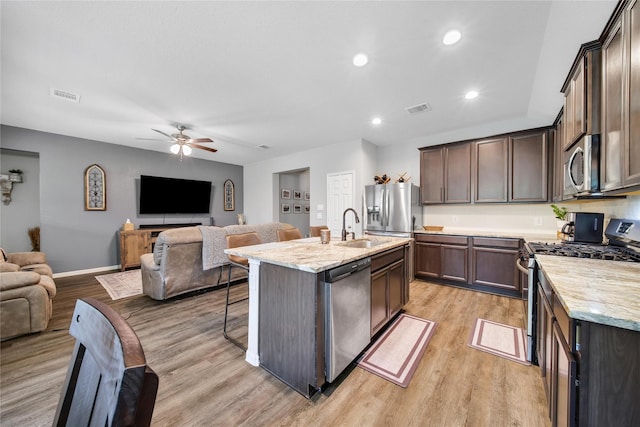 922 Golden Willow Ln, Conroe, TX 77304 - kitchen featuring stainless steel appliances, open floor plan, a sink, light wood finished floors, and recessed lighting