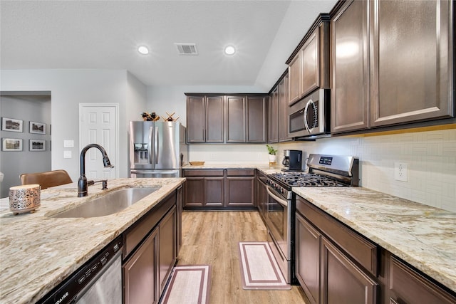 922 Golden Willow Ln, Conroe, TX 77304 - kitchen featuring appliances with stainless steel finishes, a sink, light wood finished floors, light stone counters, and recessed lighting