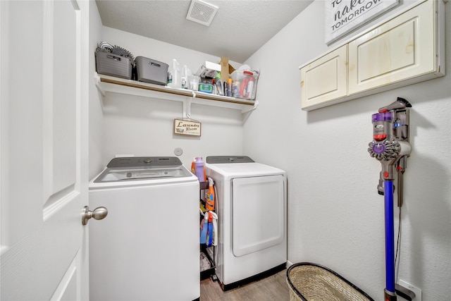 922 Golden Willow Ln, Conroe, TX 77304 - laundry room featuring separate washer and dryer, wood finished floors, and cabinet space