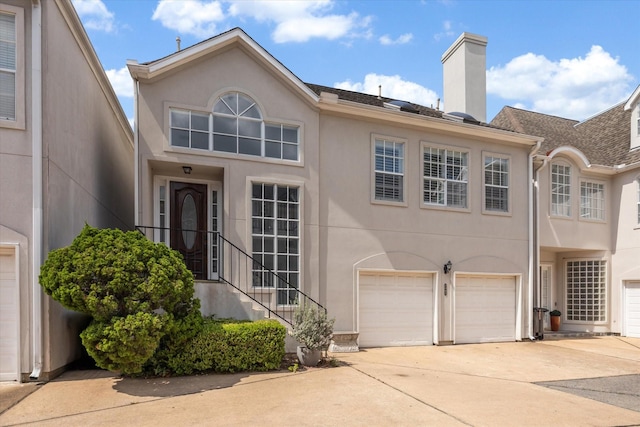 3007 Sackett St, Houston, TX 77098 - view of front of house with driveway, stucco siding, a chimney, and a garage