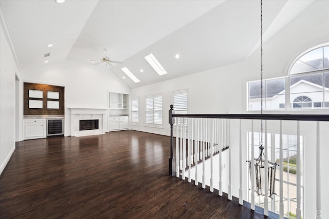3007 Sackett St, Houston, TX 77098 - unfurnished living room with wood finished floors, beverage cooler, a high end fireplace, a ceiling fan, and high vaulted ceiling