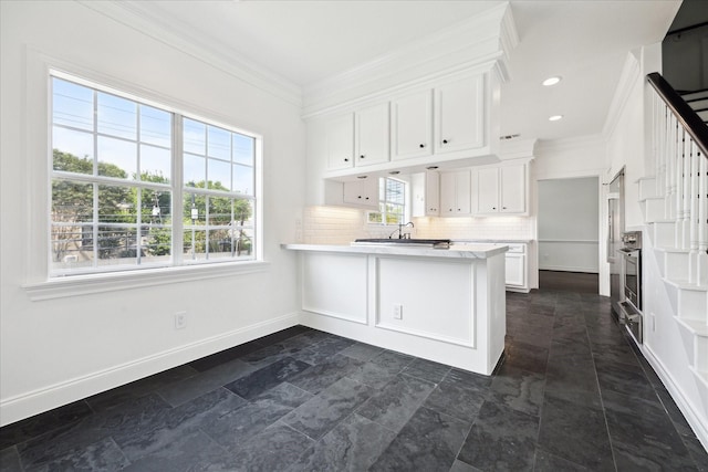 3007 Sackett St, Houston, TX 77098 - kitchen featuring crown molding, a sink, white cabinets, light countertops, and baseboards