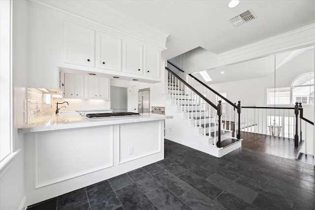 3007 Sackett St, Houston, TX 77098 - kitchen featuring white cabinetry, light countertops, decorative backsplash, a peninsula, and recessed lighting
