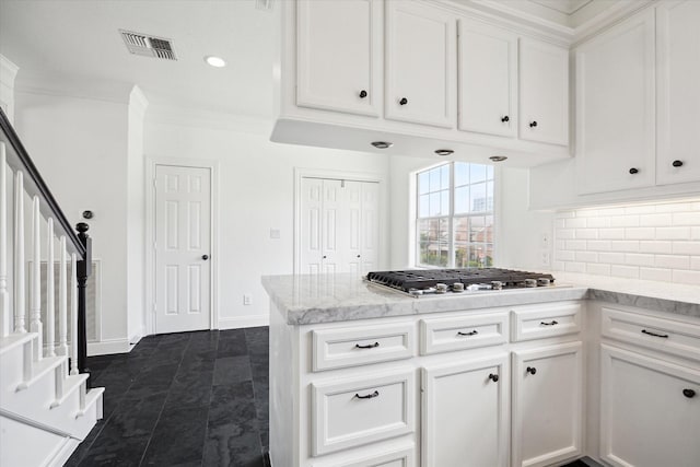 3007 Sackett St, Houston, TX 77098 - kitchen featuring stainless steel gas cooktop, white cabinets, backsplash, a peninsula, and light stone countertops
