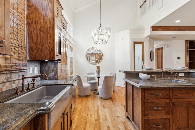 1010 Cortlandt St, Houston, TX 77008 - kitchen with a sink, decorative backsplash, dark stone countertops, glass insert cabinets, and crown molding