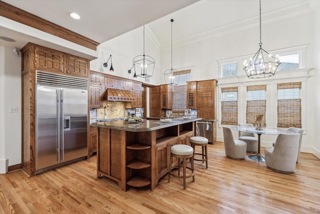1010 Cortlandt St, Houston, TX 77008 - kitchen with stainless steel appliances, a chandelier, open shelves, brown cabinetry, and ornamental molding