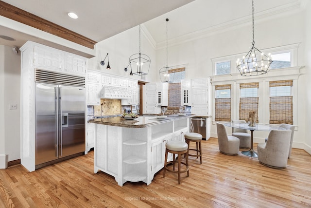 1010 Cortlandt St, Houston, TX 77008 - kitchen featuring stainless steel appliances, a chandelier, open shelves, crown molding, and a center island