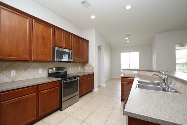 2414 Hannover Valley Ct, Spring, TX 77388 - kitchen with stainless steel appliances, a sink, decorative backsplash, arched walkways, and recessed lighting