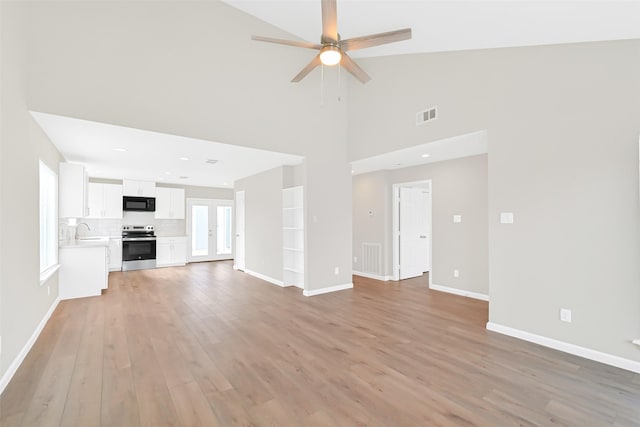 6334 Cambridge Glen Ln, Houston, TX 77035 - unfurnished living room with light wood-style floors, a ceiling fan, baseboards, high vaulted ceiling, and a sink