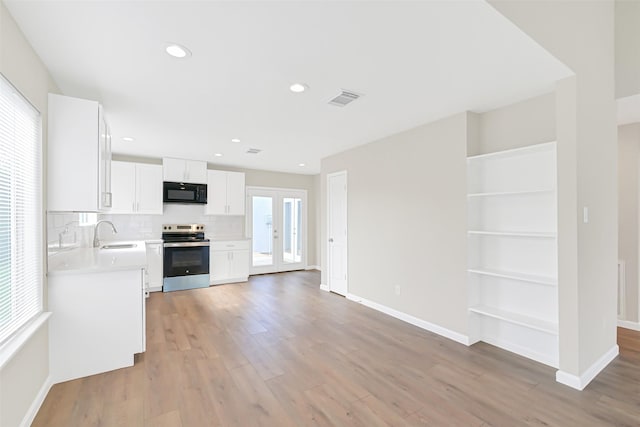 6334 Cambridge Glen Ln, Houston, TX 77035 - kitchen with stainless steel electric range, black microwave, light countertops, baseboards, and recessed lighting