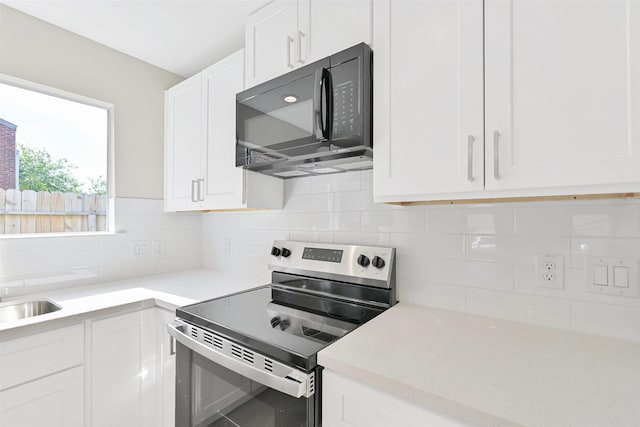 6334 Cambridge Glen Ln, Houston, TX 77035 - kitchen featuring electric range, black microwave, white cabinets, and tasteful backsplash