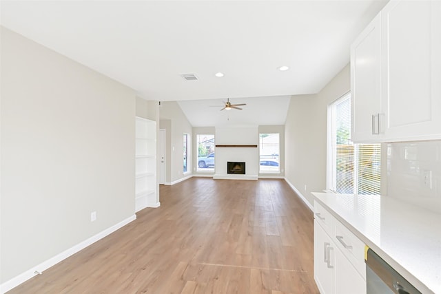 6334 Cambridge Glen Ln, Houston, TX 77035 - unfurnished living room featuring a ceiling fan, baseboards, light wood-style floors, a fireplace with raised hearth, and recessed lighting