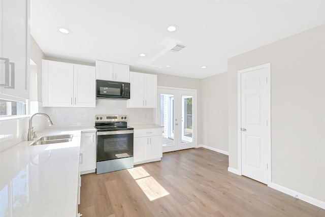 6334 Cambridge Glen Ln, Houston, TX 77035 - kitchen with stainless steel range with electric stovetop, black microwave, a sink, tasteful backsplash, and light wood-style flooring