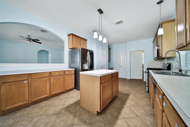 16655 Millridge Ln, Houston, TX 77095 - kitchen with stainless steel appliances, a kitchen island, a sink, ceiling fan, and brown cabinets