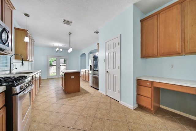 16655 Millridge Ln, Houston, TX 77095 - kitchen with stainless steel appliances, brown cabinets, light countertops, a sink, and light tile patterned flooring
