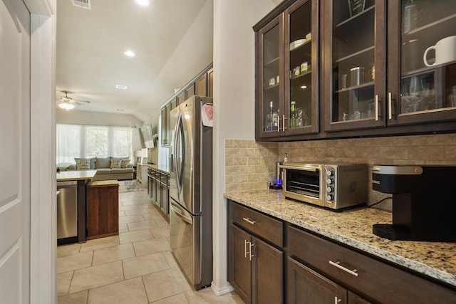 22078 Sun Haven Ln, Porter, TX 77365 - kitchen featuring stainless steel appliances, dark brown cabinetry, decorative backsplash, light stone counters, and light tile patterned floors