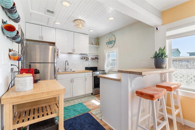 1010 Fort Velasco Dr, Surfside Beach, TX 77541 - kitchen featuring wooden counters, appliances with stainless steel finishes, a sink, healthy amount of natural light, and recessed lighting